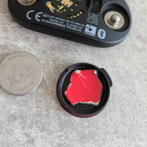Couvercle du Polar H10 avec morceau de papier carte postale pour stabiliser la pile CR2025
